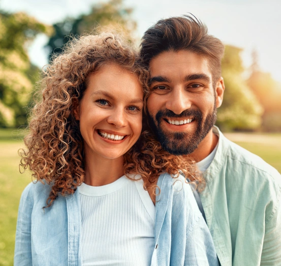 A happy couple showing off healthy smiles, highlighting the benefits of routine preventive dental care.