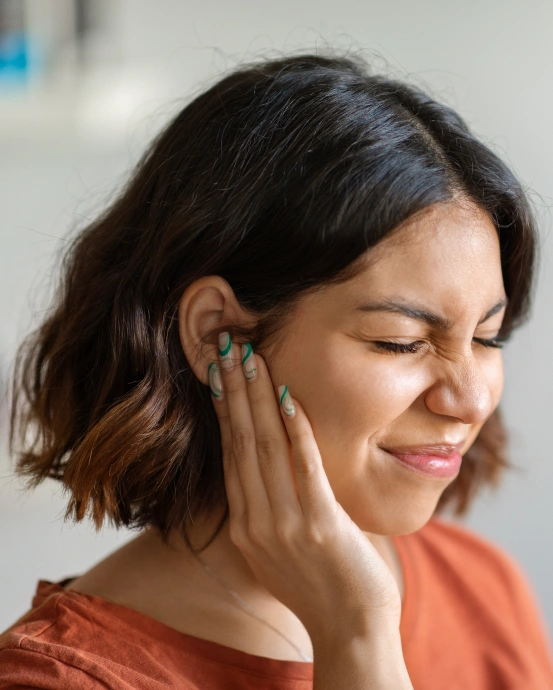 Woman holding her jaw due to TMJ pain, illustrating temporomandibular joint disorder treatment at South Arlington Smiles in Arlington, TX.